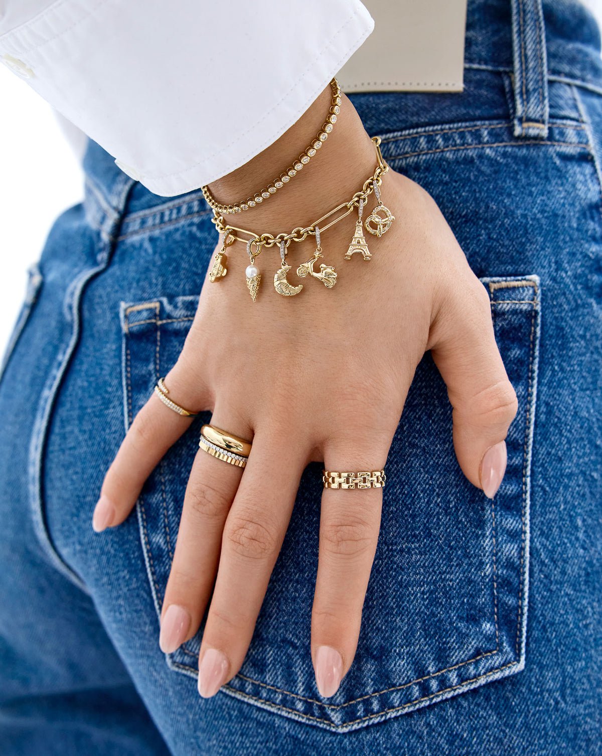 Croissant Charm in 14k solid gold on bracelet chain paired with a variety of other gold charms worn by model