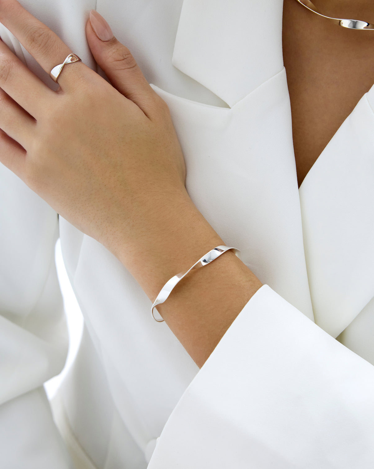 Silver Twist Cuff on Model's wrist styled with matching ring and necklace