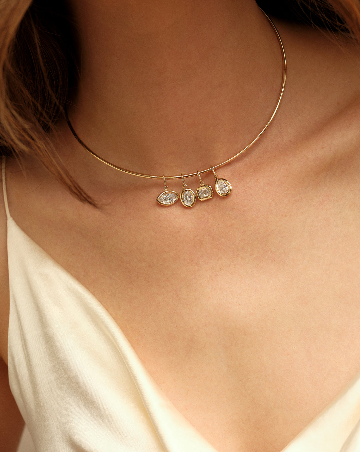 Close-up detail of 14k yellow gold collar necklace styled with pendants on-model