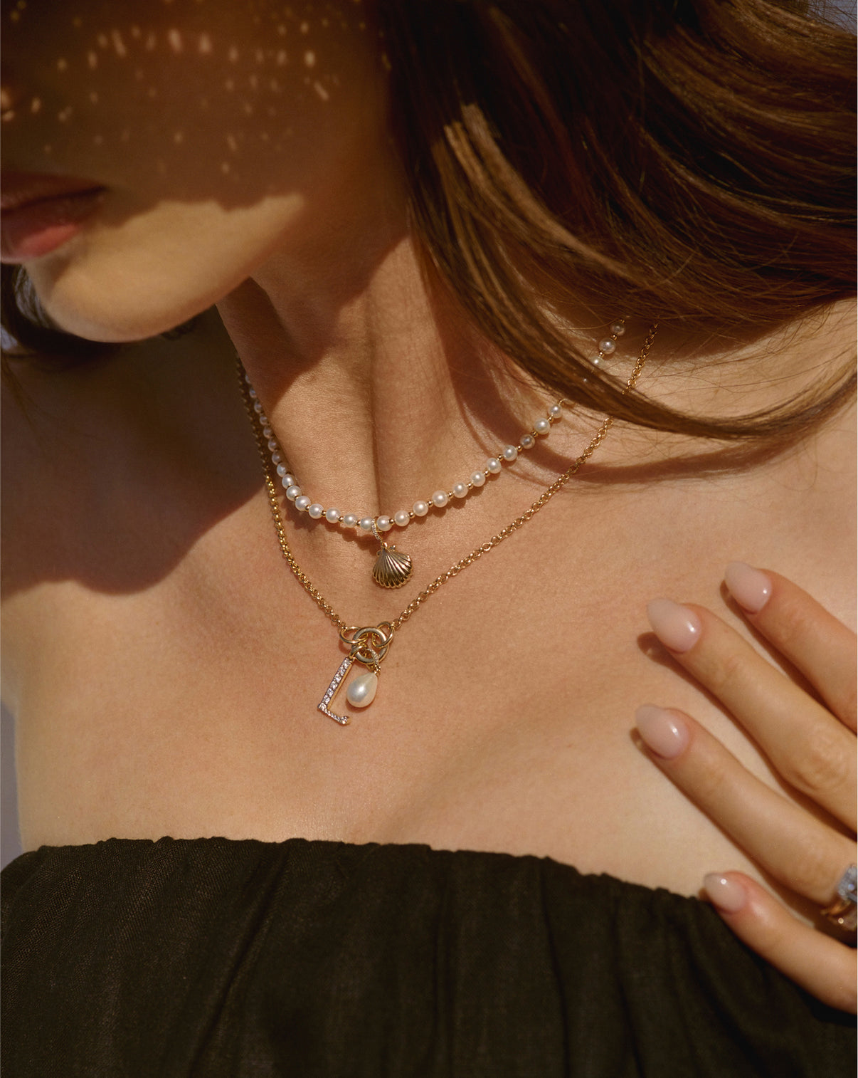 Pearl Station Necklace worn by model, showcasing how the pearls elegantly drape around the neck