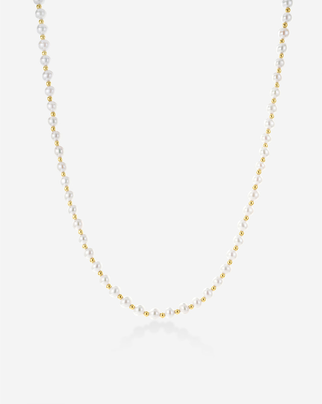 Pearl Station Necklace featuring delicate freshwater pearls spaced along a fine gold chain, displayed on a light background