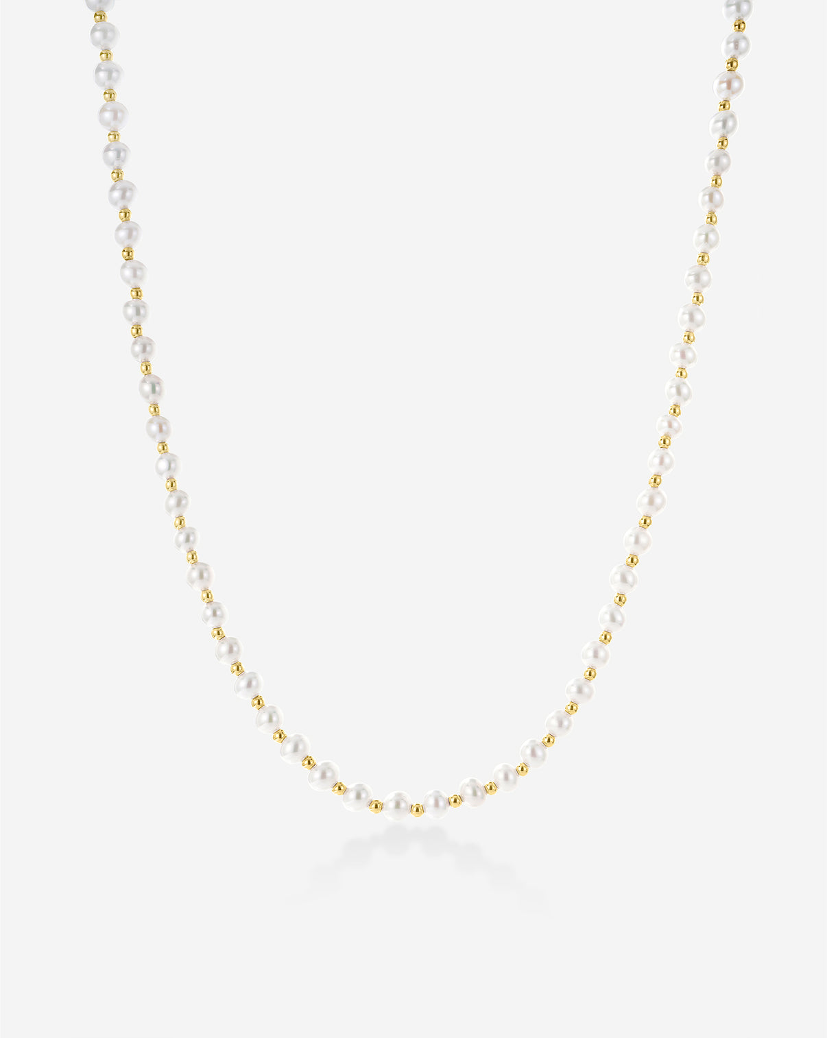 Pearl Station Necklace featuring delicate freshwater pearls spaced along a fine gold chain, displayed on a light background
