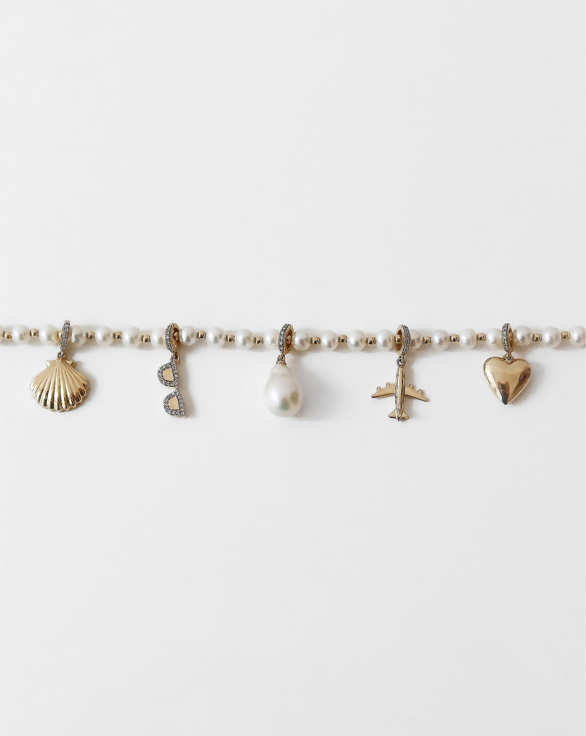 Multiple charms on pearl station bracelet