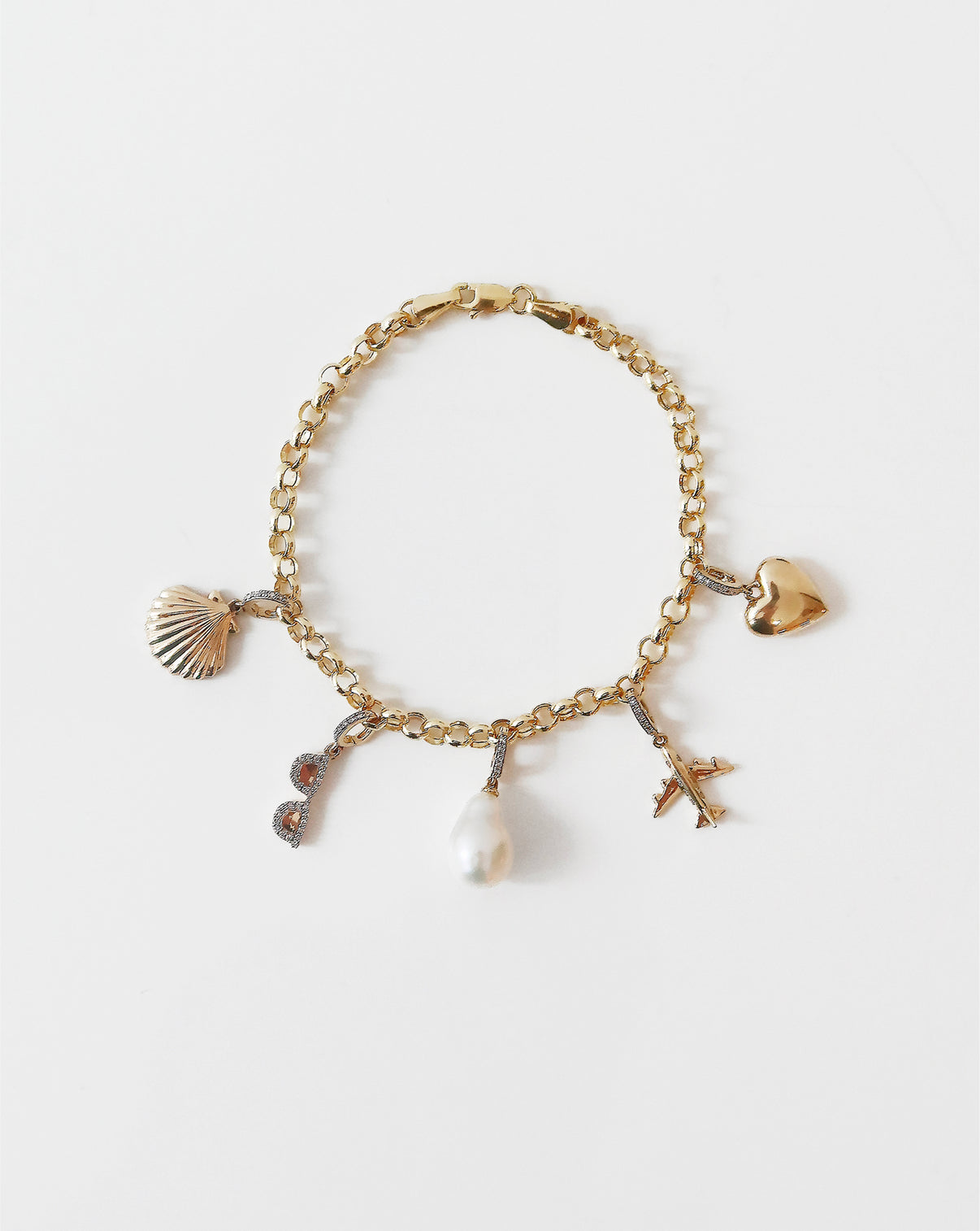 Multiple charms stacked on hollow rolo chain bracelet