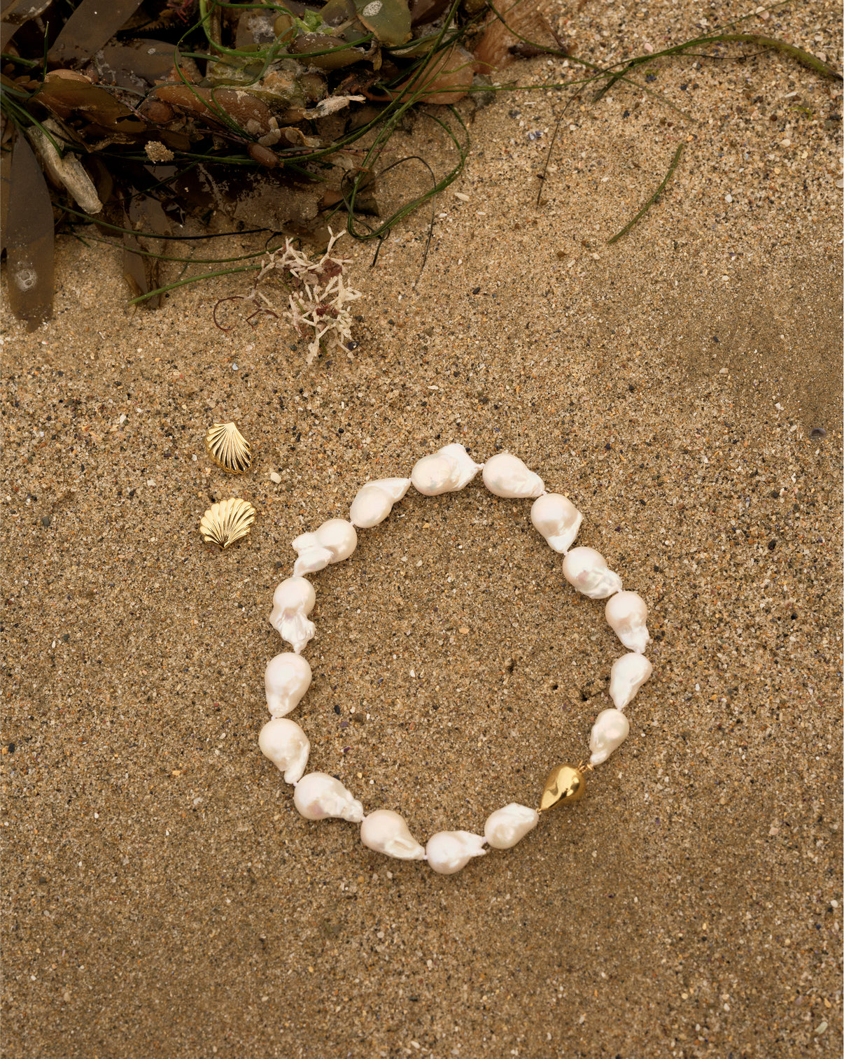 Shell earrings with Baroque pearl necklace in the sand