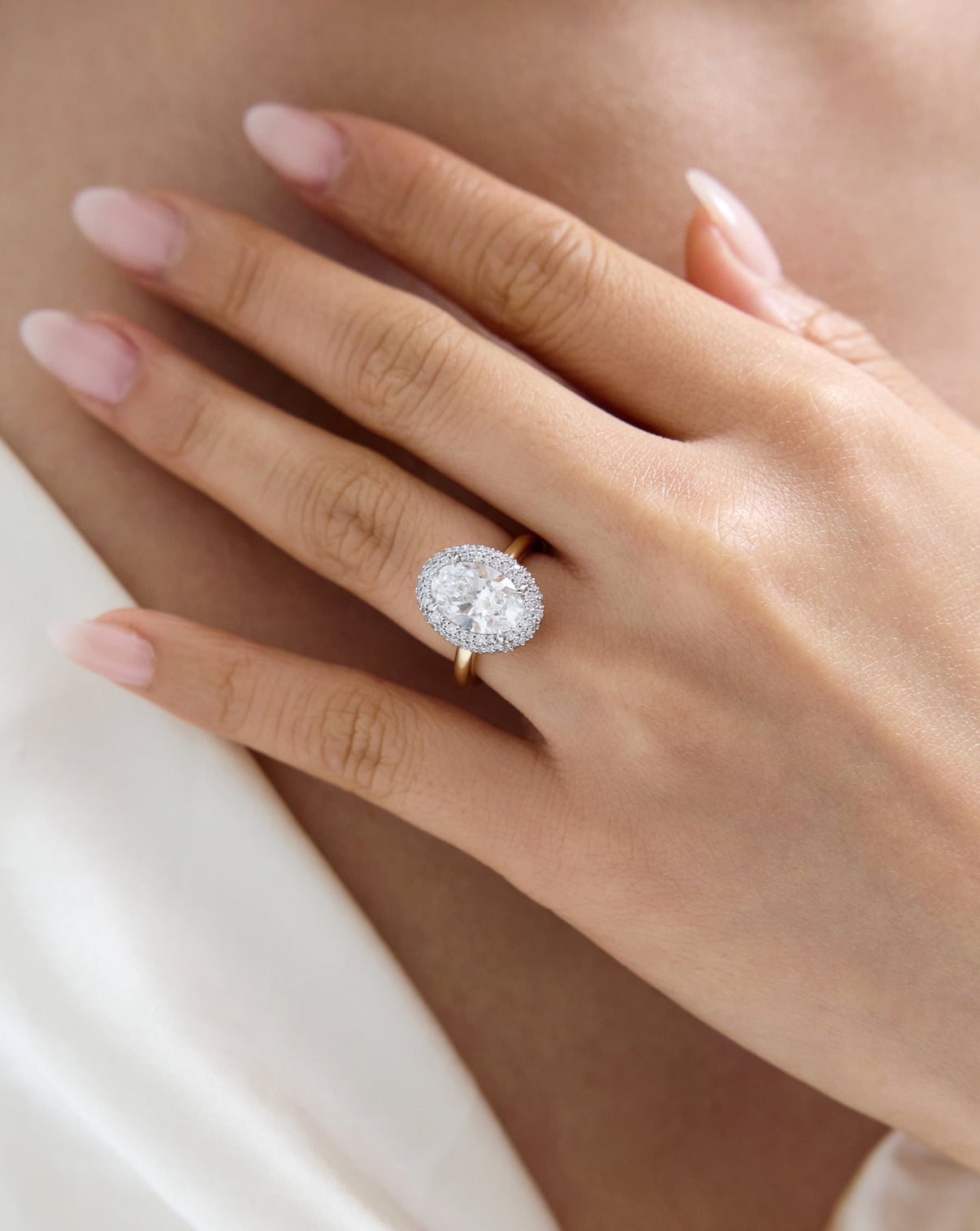 Close up view of Cloud Bezel with Pavé Halo in Yellow Gold worn on model's hand 44181311979608 44181328461912 44181328494680