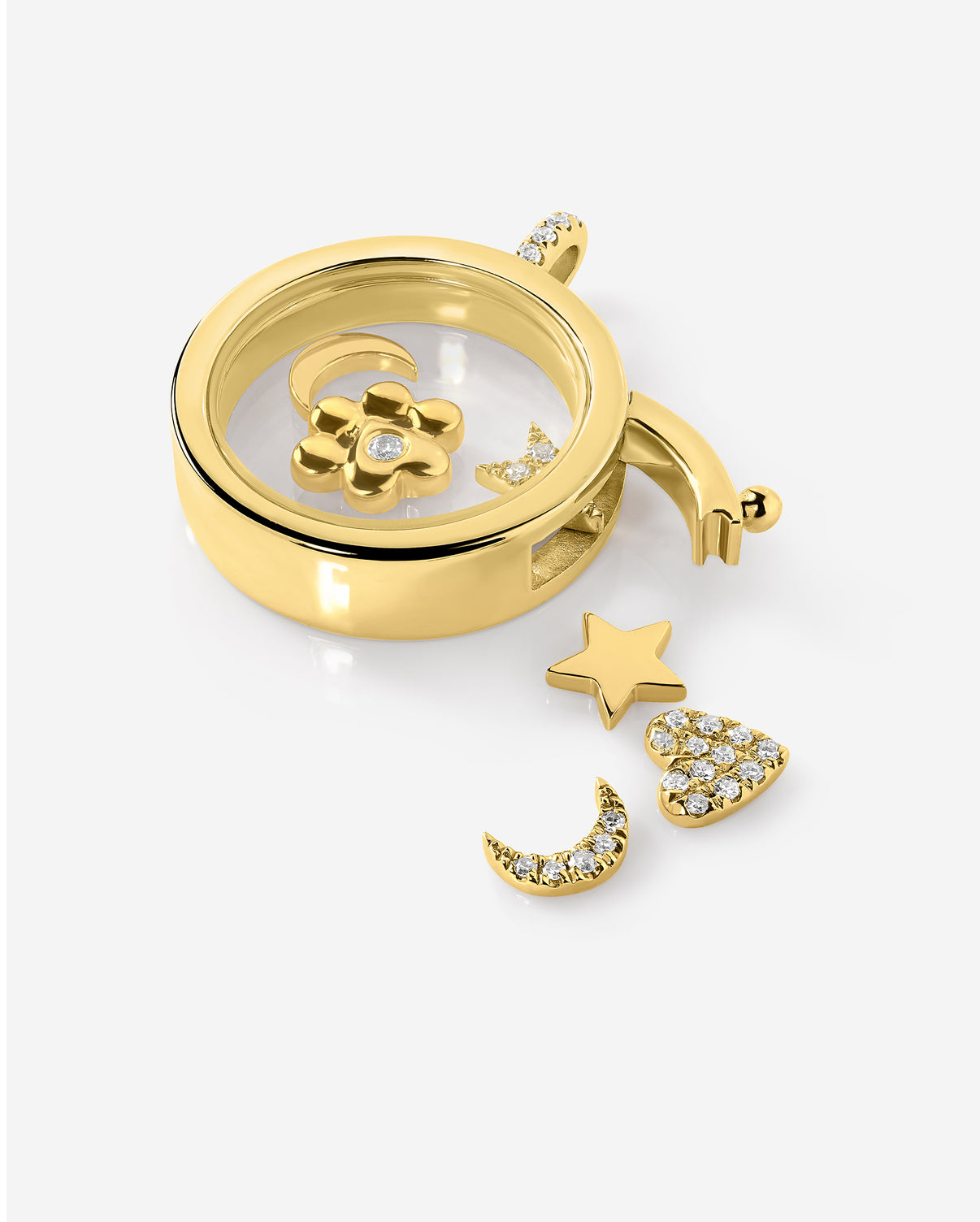 close up of the pave moon, heart, and star charms surrounding an open charm locket along with other gold charms global