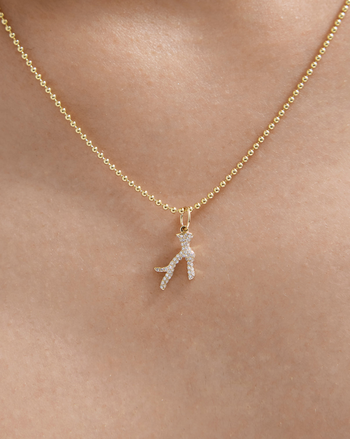 Close up of 14k solid gold Jewel Reef Charm worn on gold chain