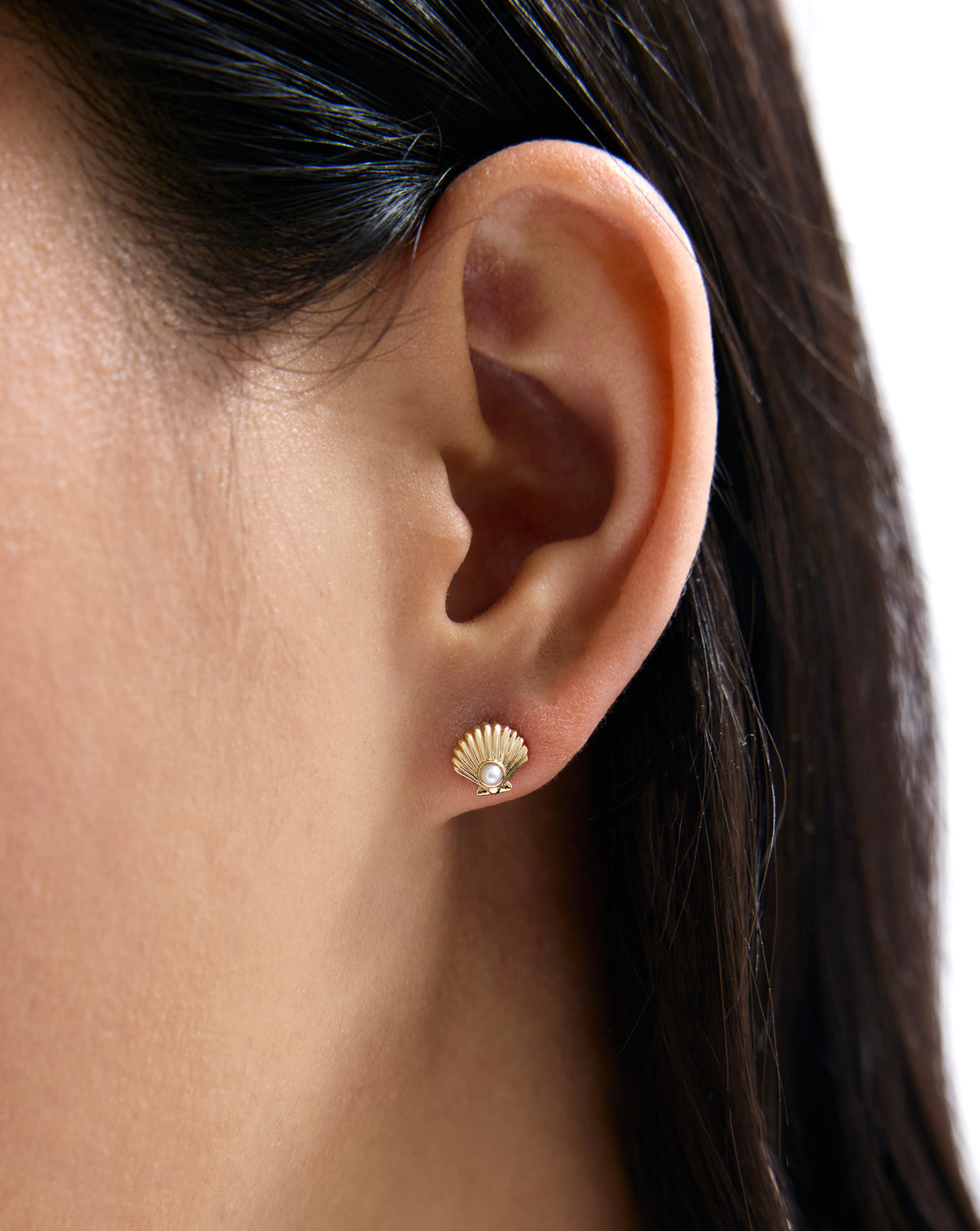 Seashell and Pearl Studs worn on ear, demonstrating how they sit on the earlobe