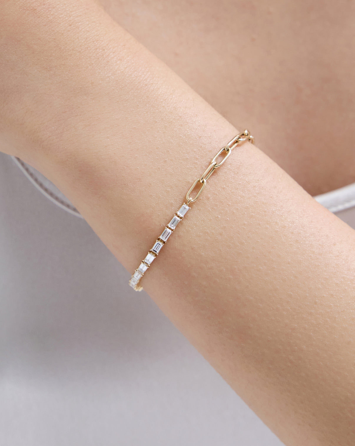 Close up of model wearing our 14k solid gold Baguette Lab Diamond Tennis Chain Bracelet showcasing diamond and chain details