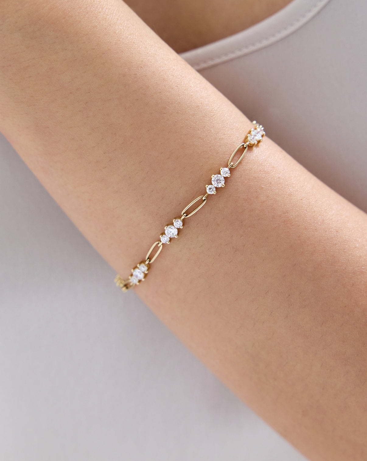Close up of model wearing our 14k solid gold Graduated Lab Diamond Chain Bracelet on arm