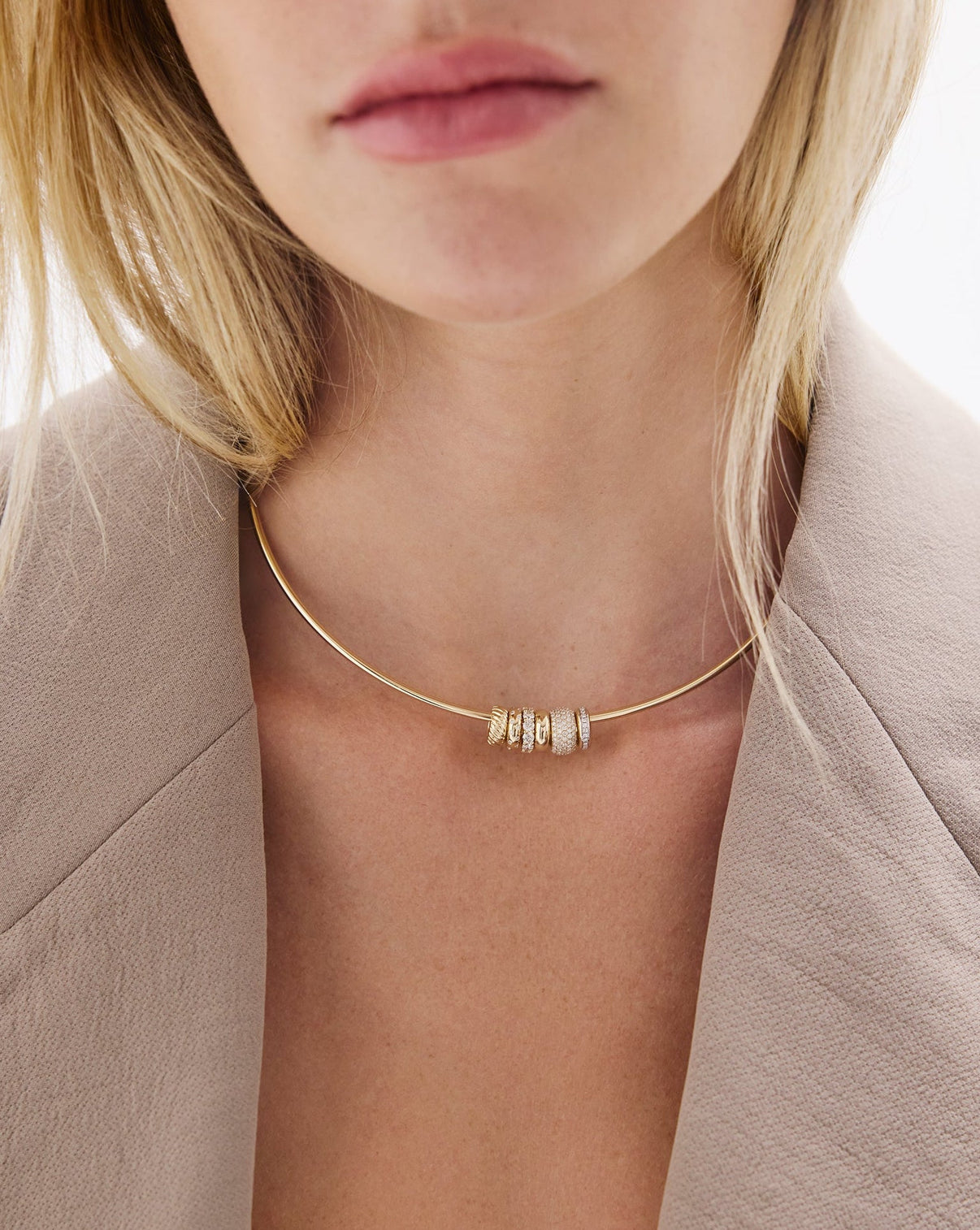 Necklace with beads worn by a person against a neutral background