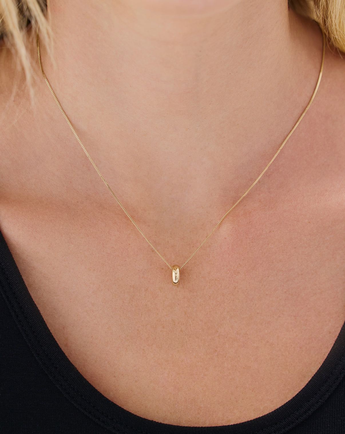 14k yellow gold bead charm shown in everyday jewelry styling