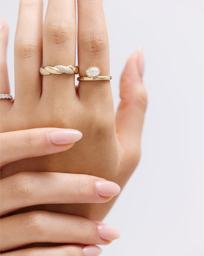 Top-down view of oval bezel ring highlighting the off-set oval lab diamond and modern gold band design