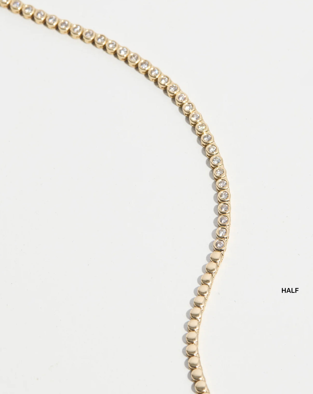 flat lay of bezel tennis necklace 14k yellow gold