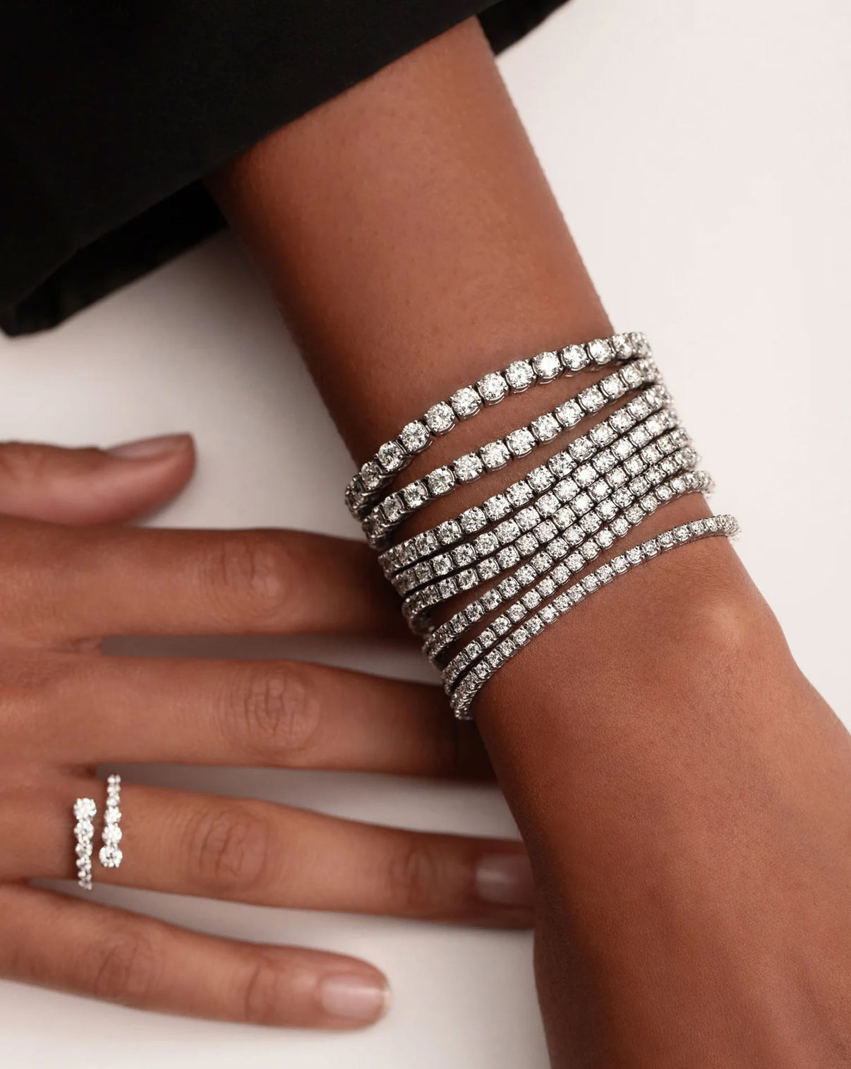 Classic diamond tennis bracelet clasp detail showing and styled with multiple bracelet GLOBAL