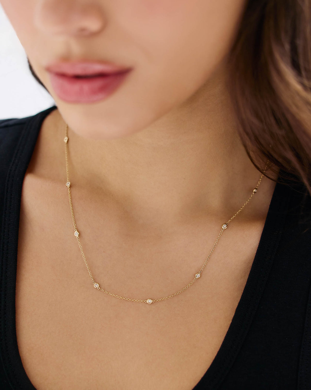 Close-up of diamond bezel station necklace showing bezel-set diamonds and delicate gold chain