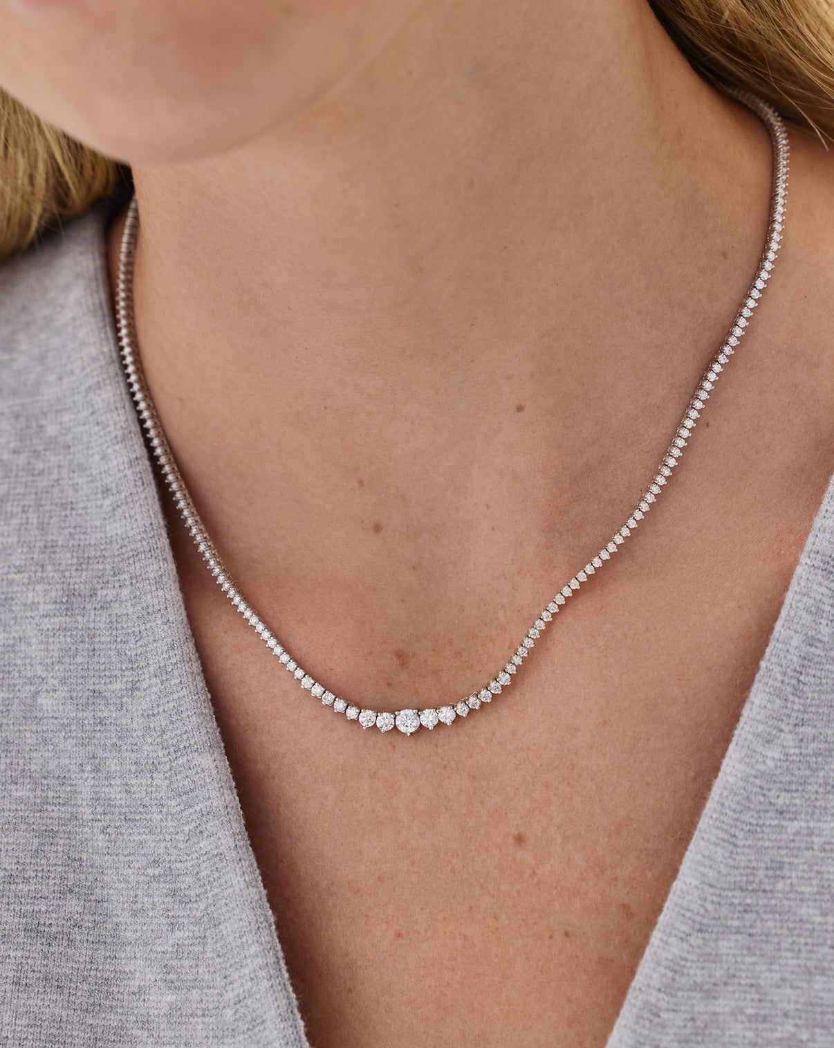 Close-up of model wearing Graduated Diamond Tennis Necklace, highlighting the natural G-H color diamonds and graduated sizing effect