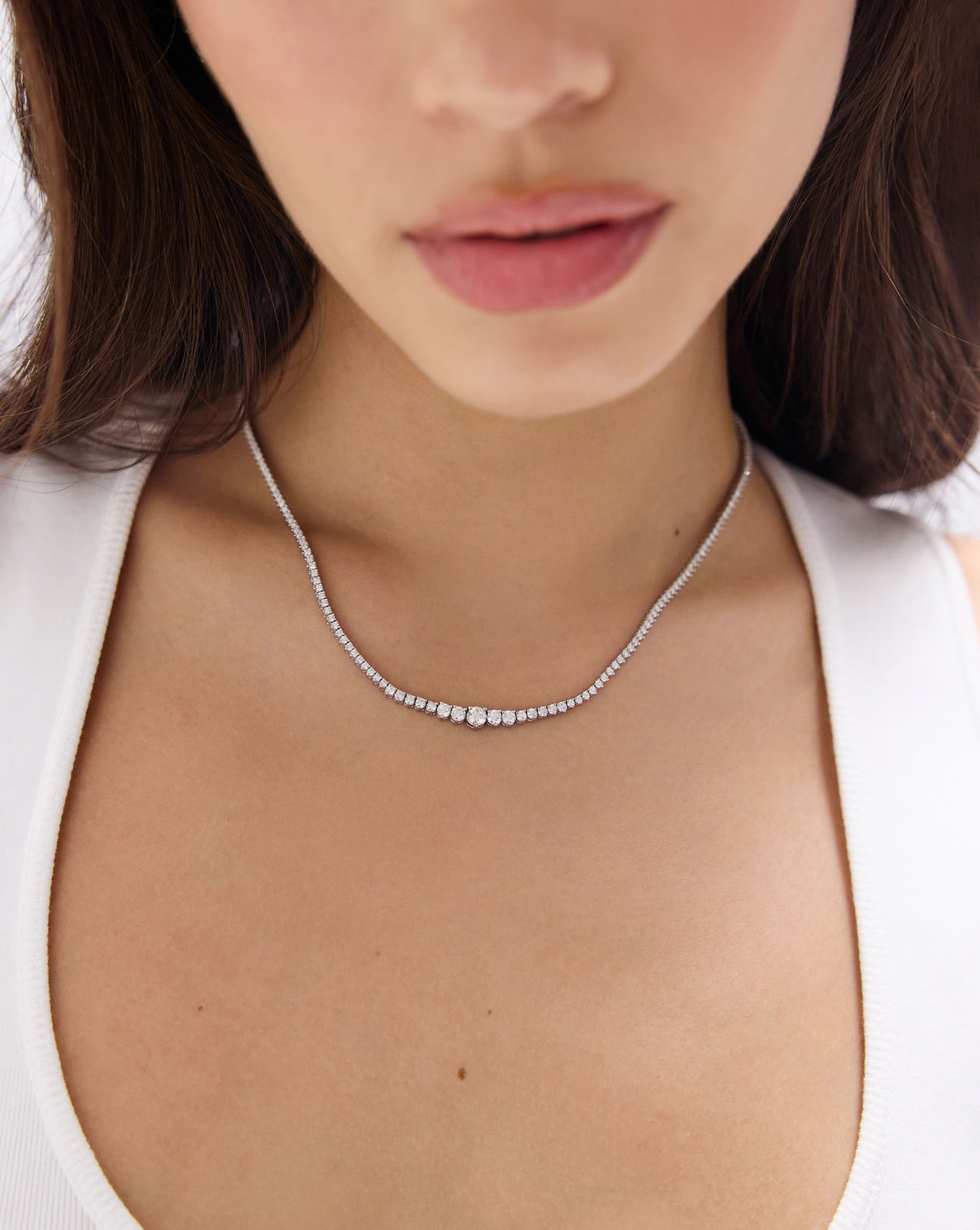 Portrait of model wearing 17-inch Graduated Diamond Tennis Necklace, featuring approximately 5-15 carats of natural diamonds in 14k solid gold