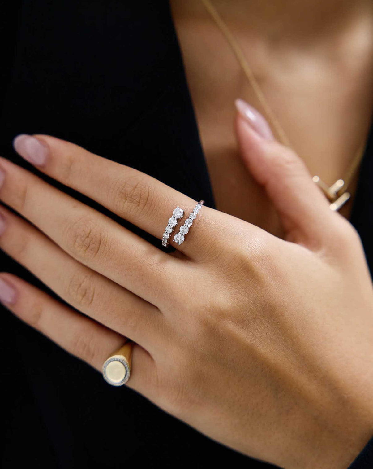 Model wearing Graduated Diamond Wrap Ring in 14k white gold on her index finger and a Pavé Diamond Border Signet Ring on her pinky finger