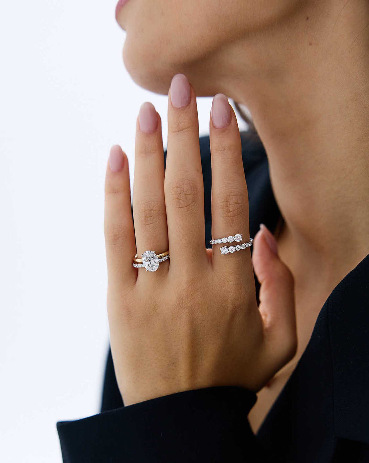 Model wearing Graduated Diamond Wrap Ring in 14k white gold and an Oval Engagement Ring