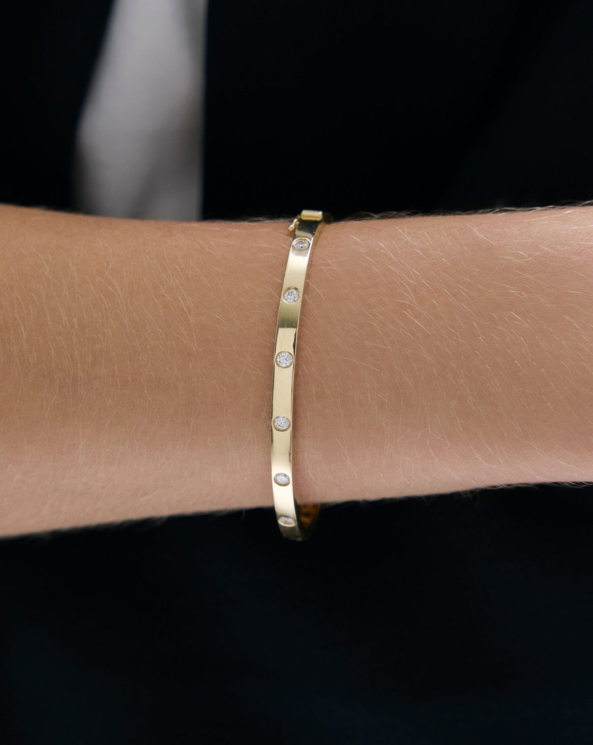 Model wearing Inlay Diamond Bangle on wrist, demonstrating how the piece complements everyday styling global