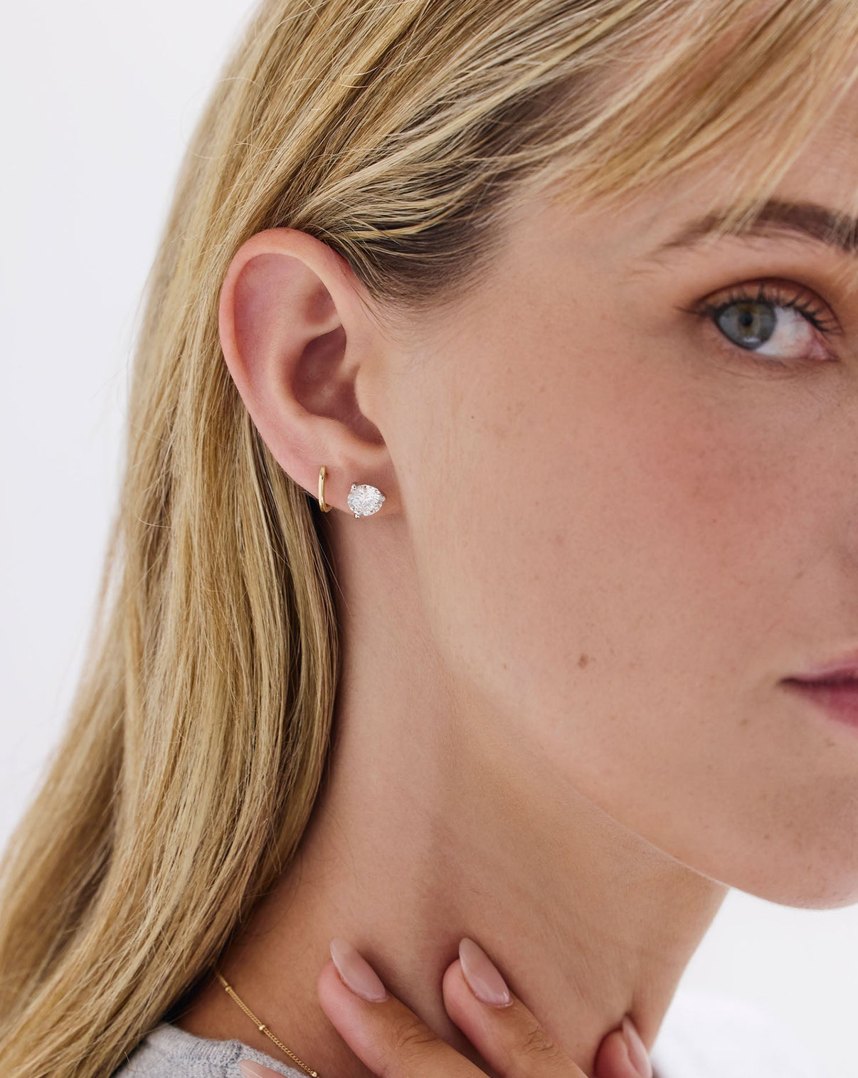 Classic Gold Huggies earrings styled with diamond earrings on model's ear
