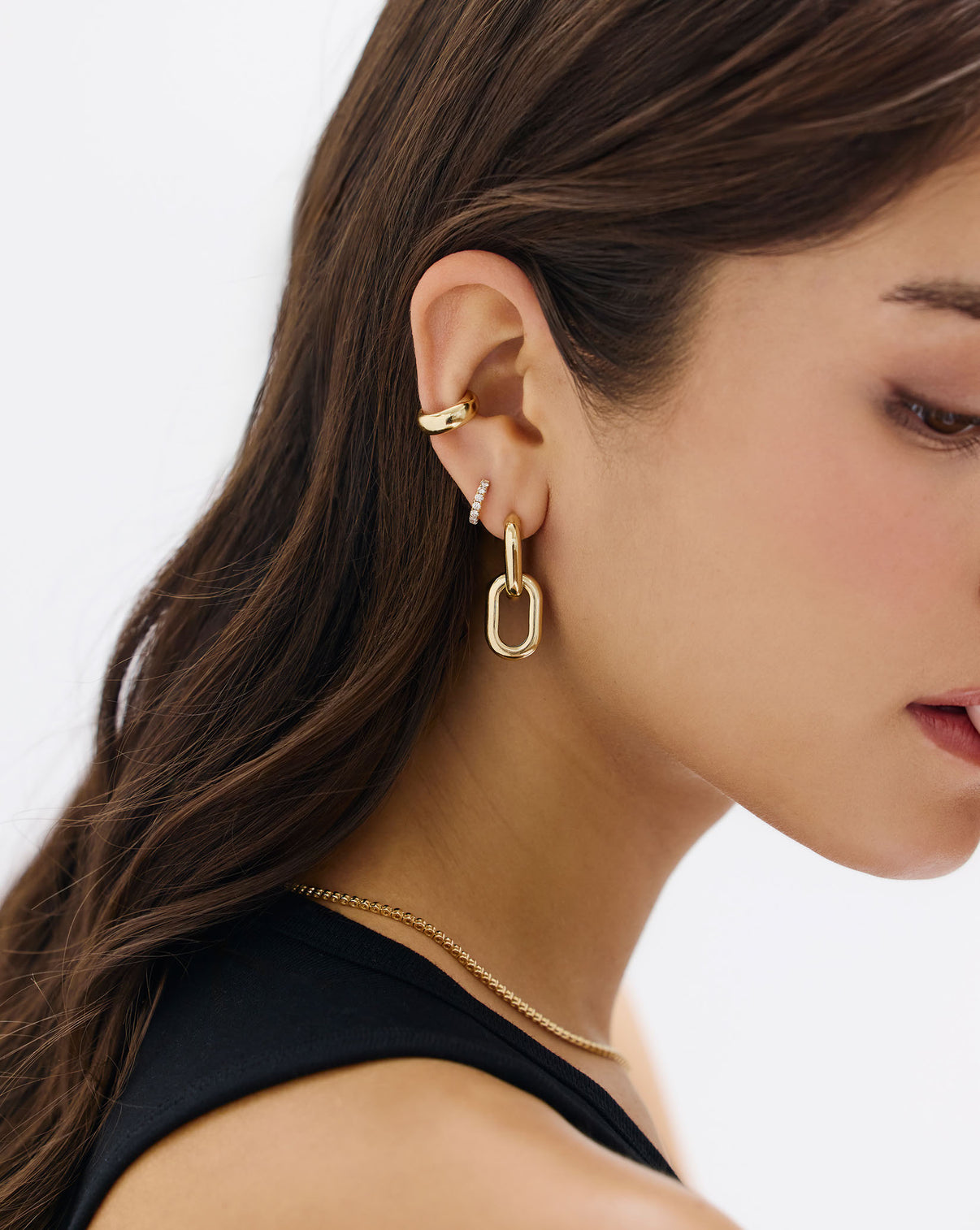 Close-up detail view of Petite Jumbo Diamond Huggies showing diamond sparkle and gold finish paired with other gold earrings