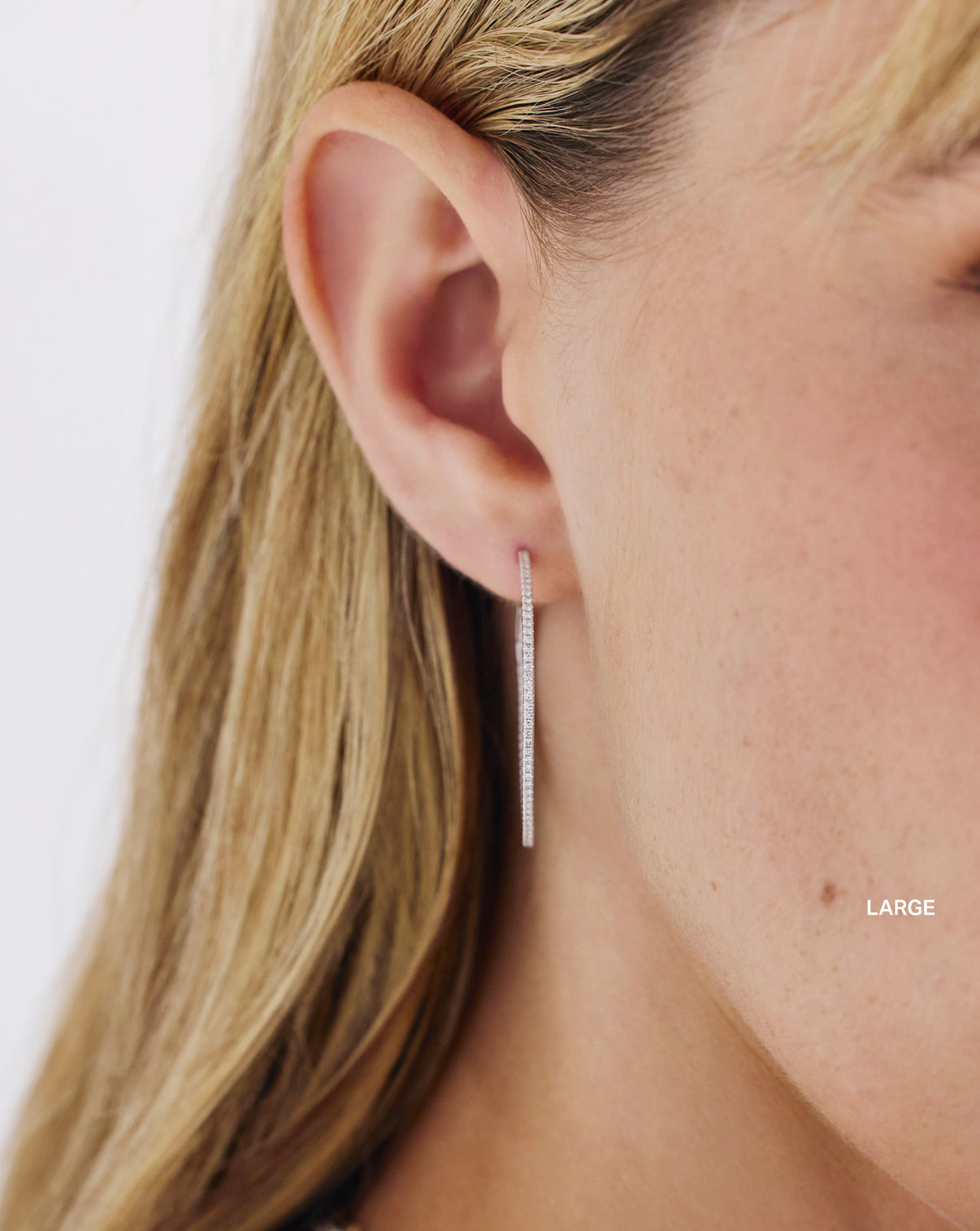 Model wearing diamond hoop earrings demonstrating how they look when styled