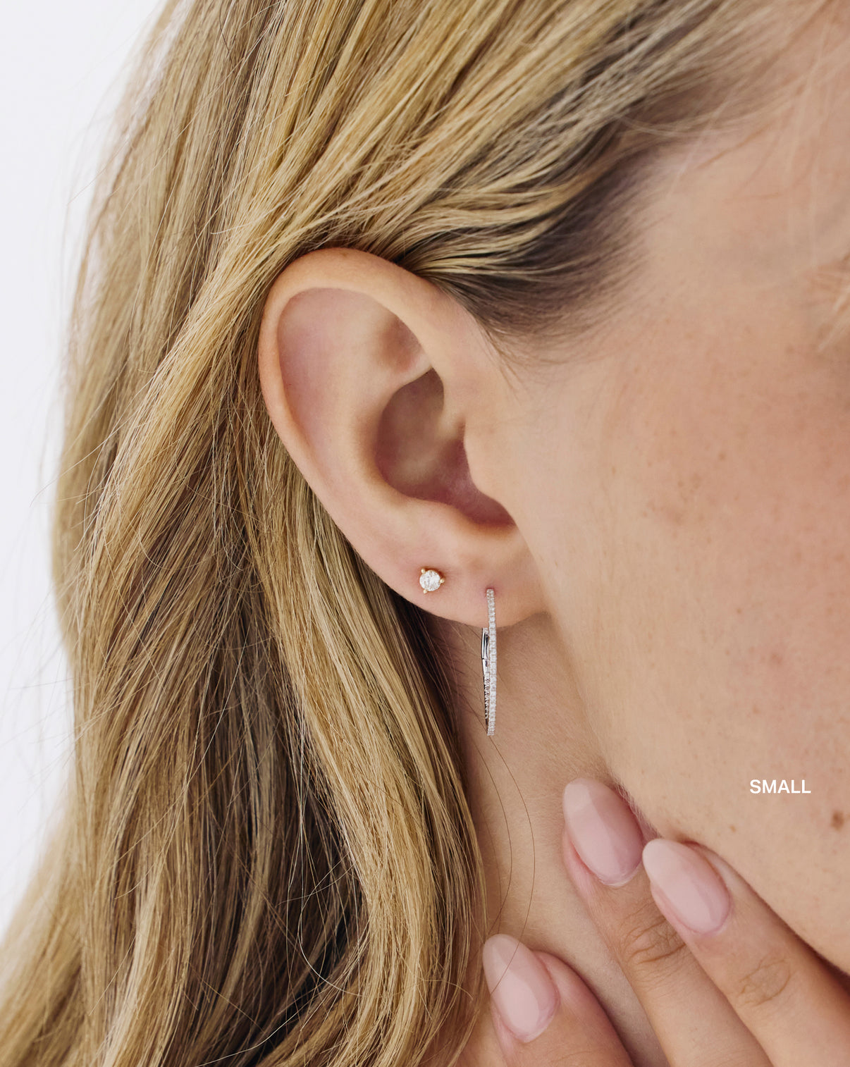 Model styling diamond hoop earrings, highlighting their versatile appeal