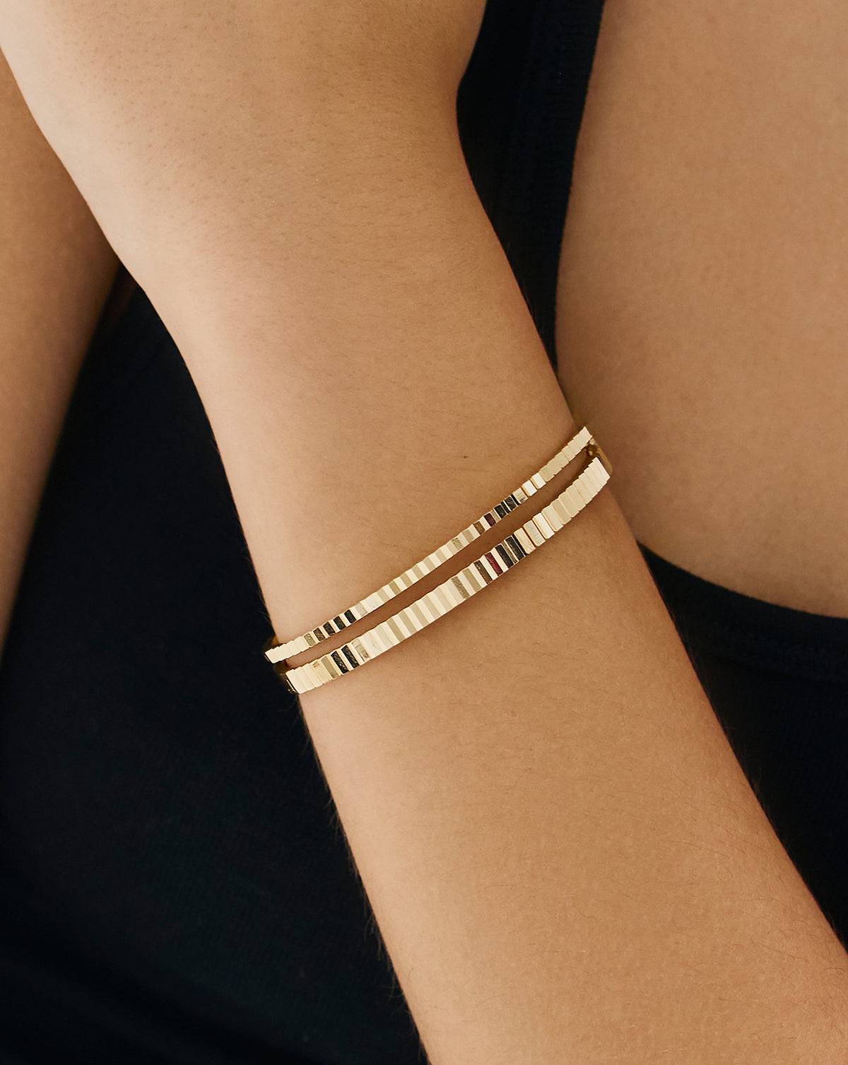 Model wearing Fluted Gold Bangle in elegant hand pose - luxury gold bracelet with ridged texture by Ring Concierge
