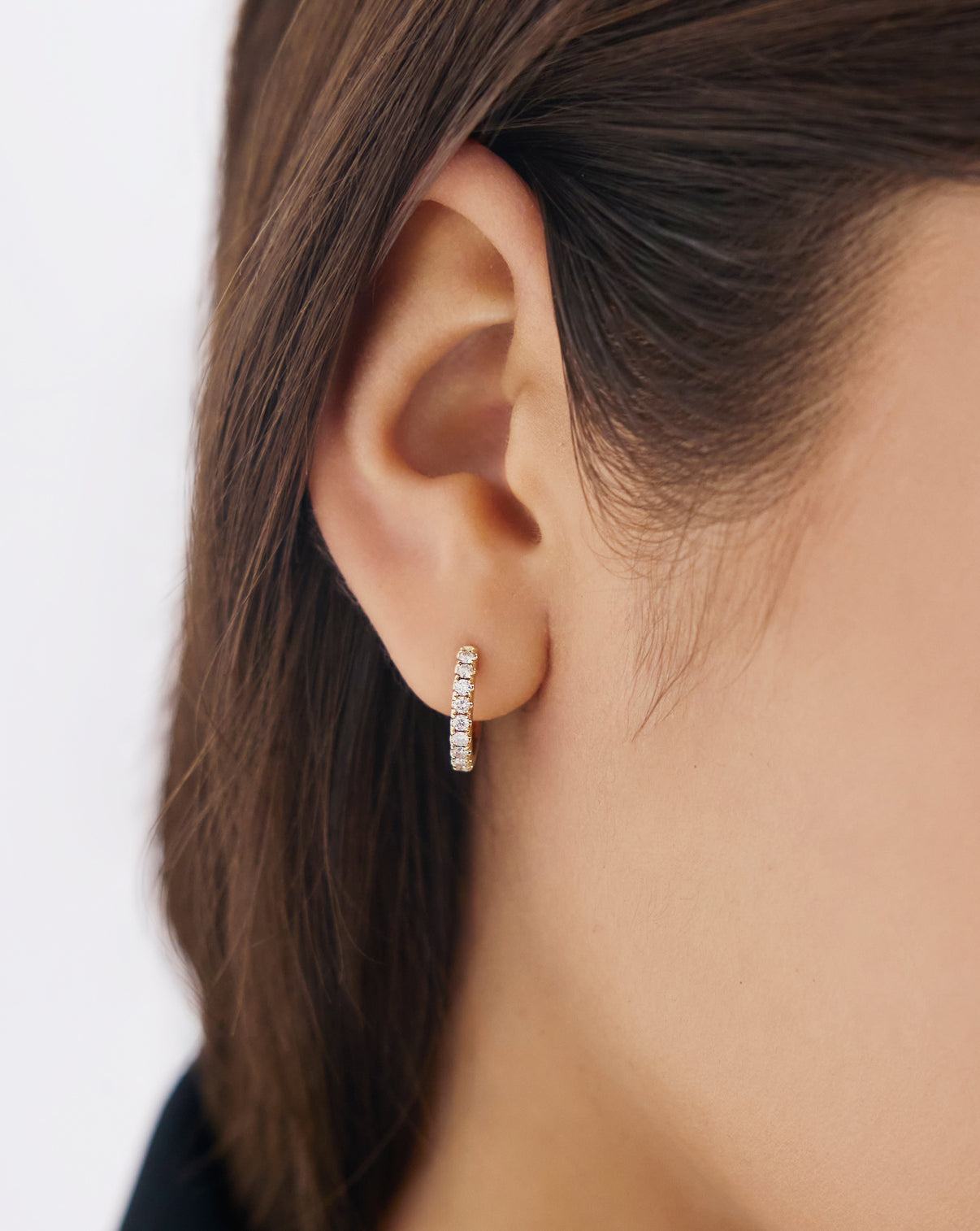 Model wearing Jumbo Diamond Huggies earrings, showcasing the luxurious diamond-encrusted hoop design on ear