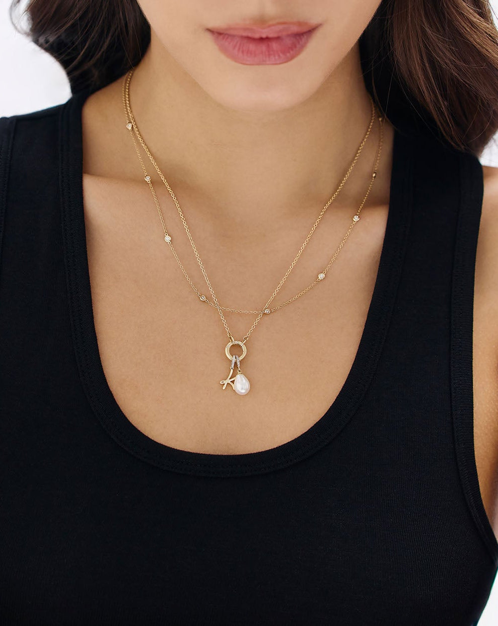 On-model image of clique cable chain necklace with enhancer and charms styled with a diamond and gold necklace
