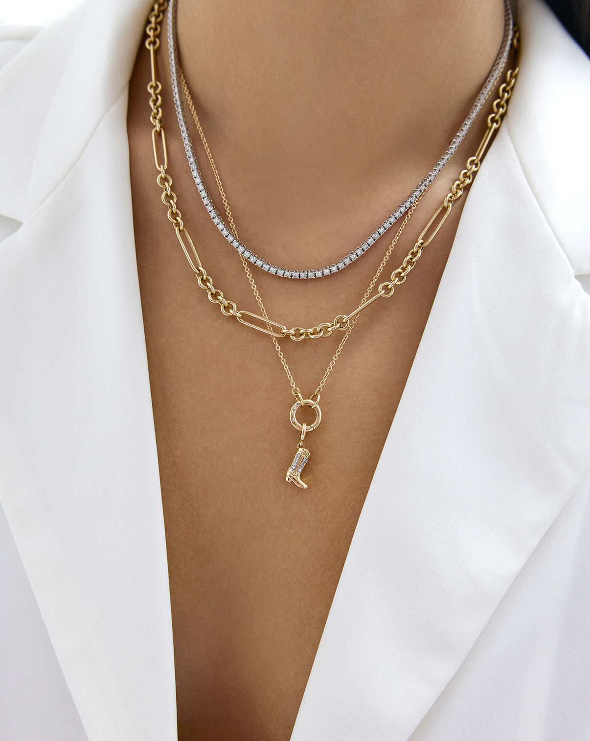 On-model image of clique cable chain necklace with enhancer and charms styled with a diamond necklace and gold layering necklace