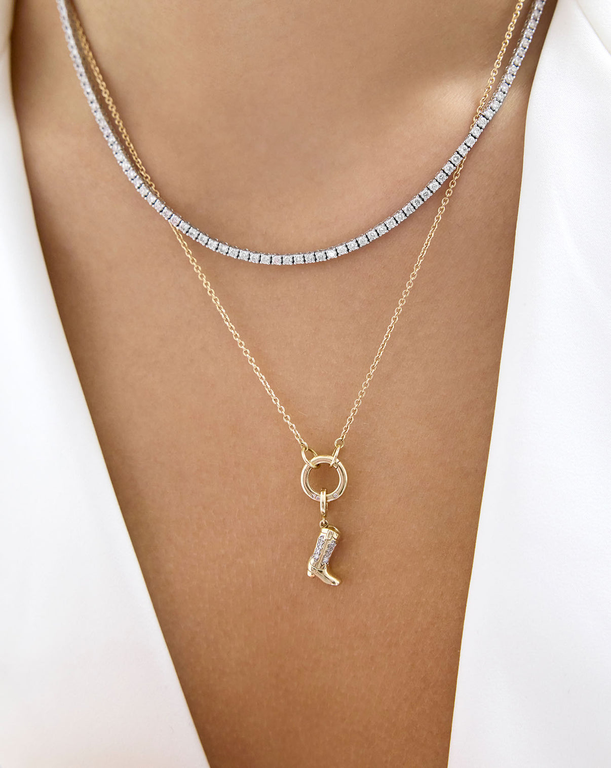Delicate Gold Necklace styled with a Cowboy boot charm and diamond tennis necklace on a model