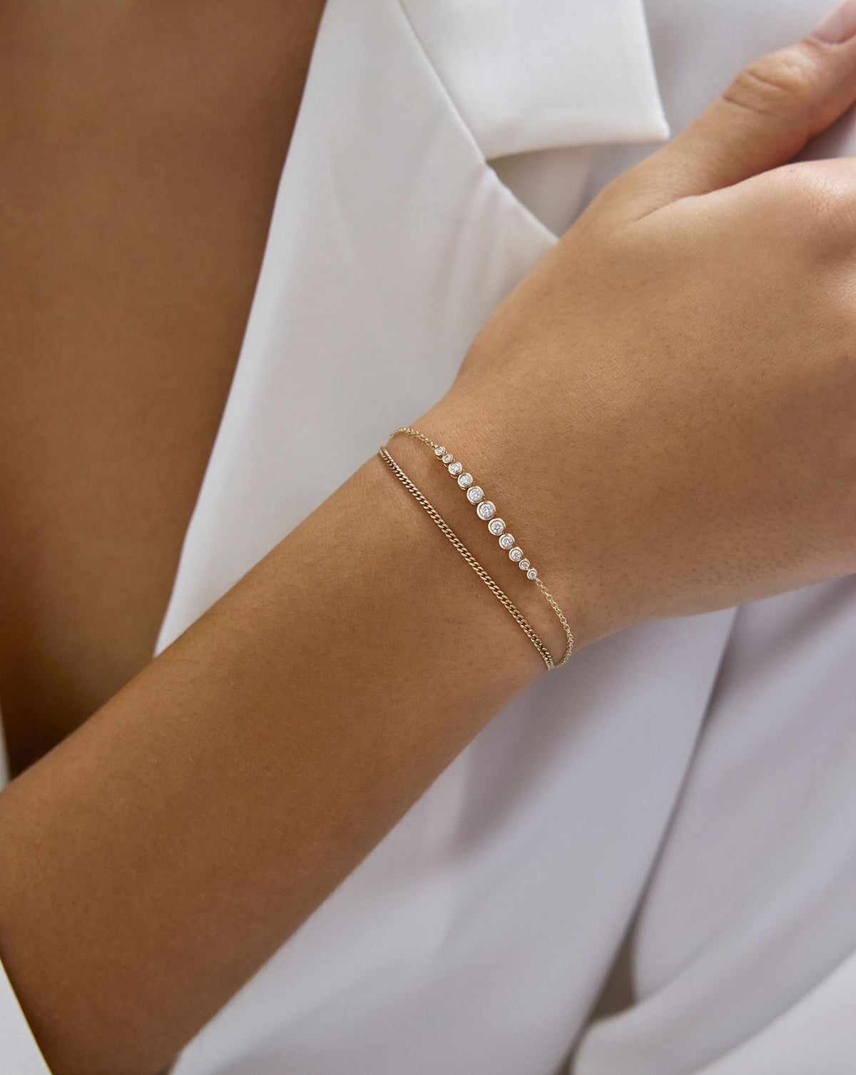 Diamond Cut Curb Chain Bracelet shown on model's wrist styled with a diamond and gold bracelet