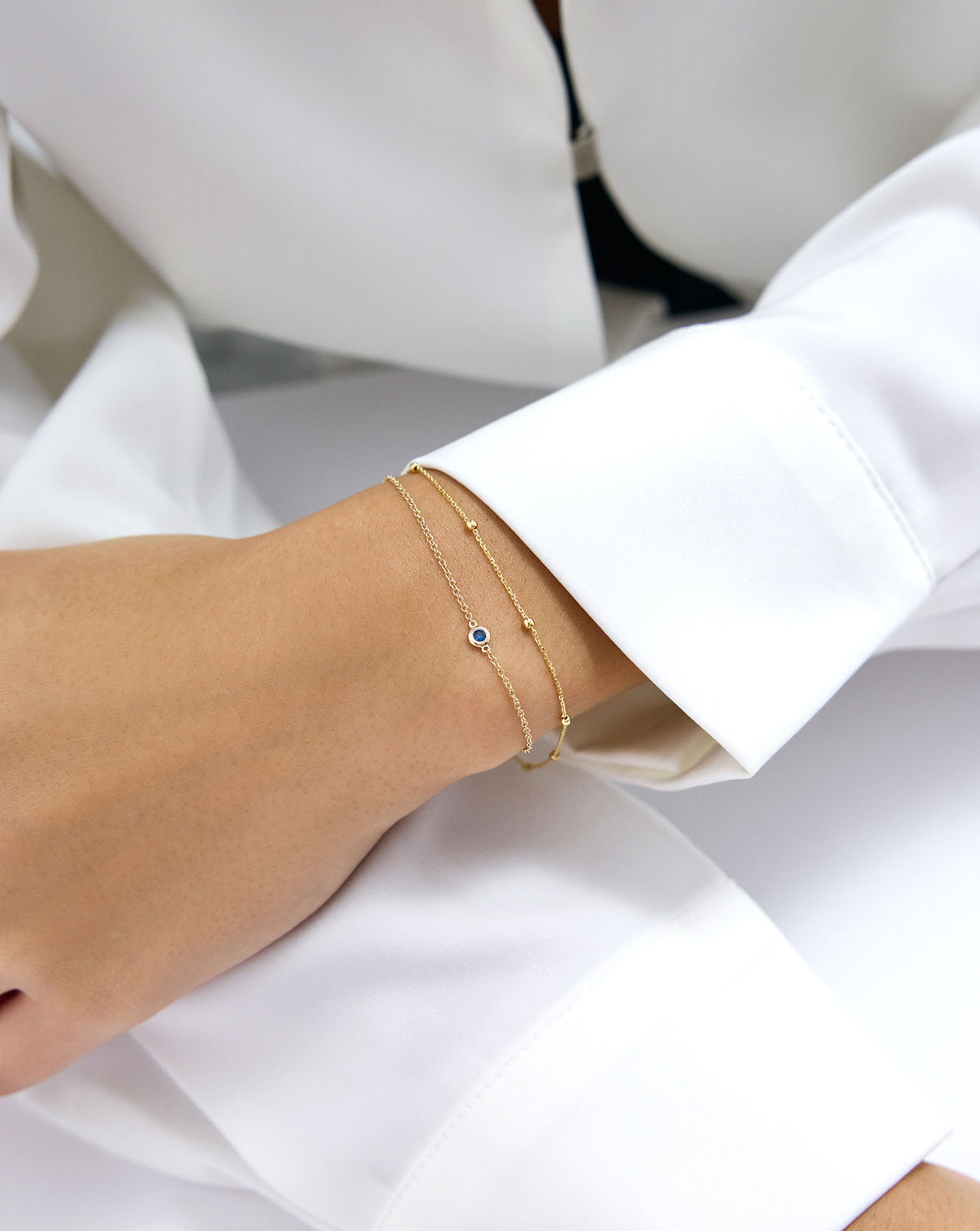 Gemstone Bezel-Set Bracelet in Sapphire Blue on model styled with a gold braclet - global