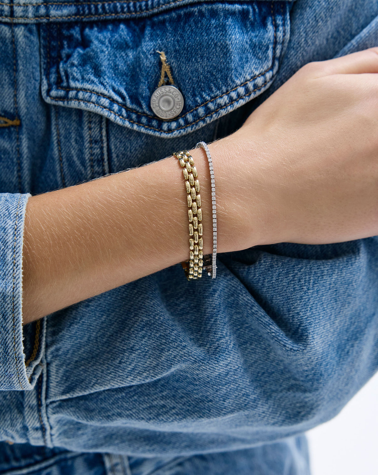 on-model image of chain bracelet in yellow gold styled with diamond bracelet