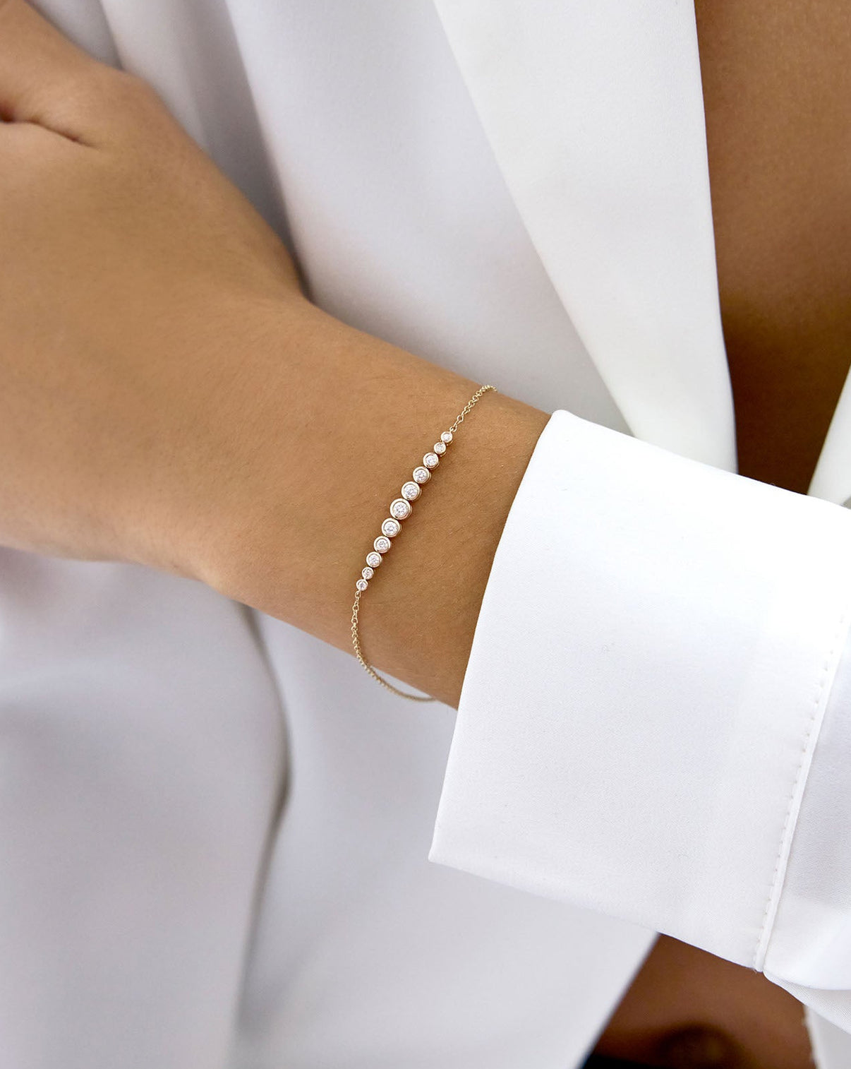 model wearing 14k Yellow Gold Graduated Diamond Bezel Soft Chain Bracelet