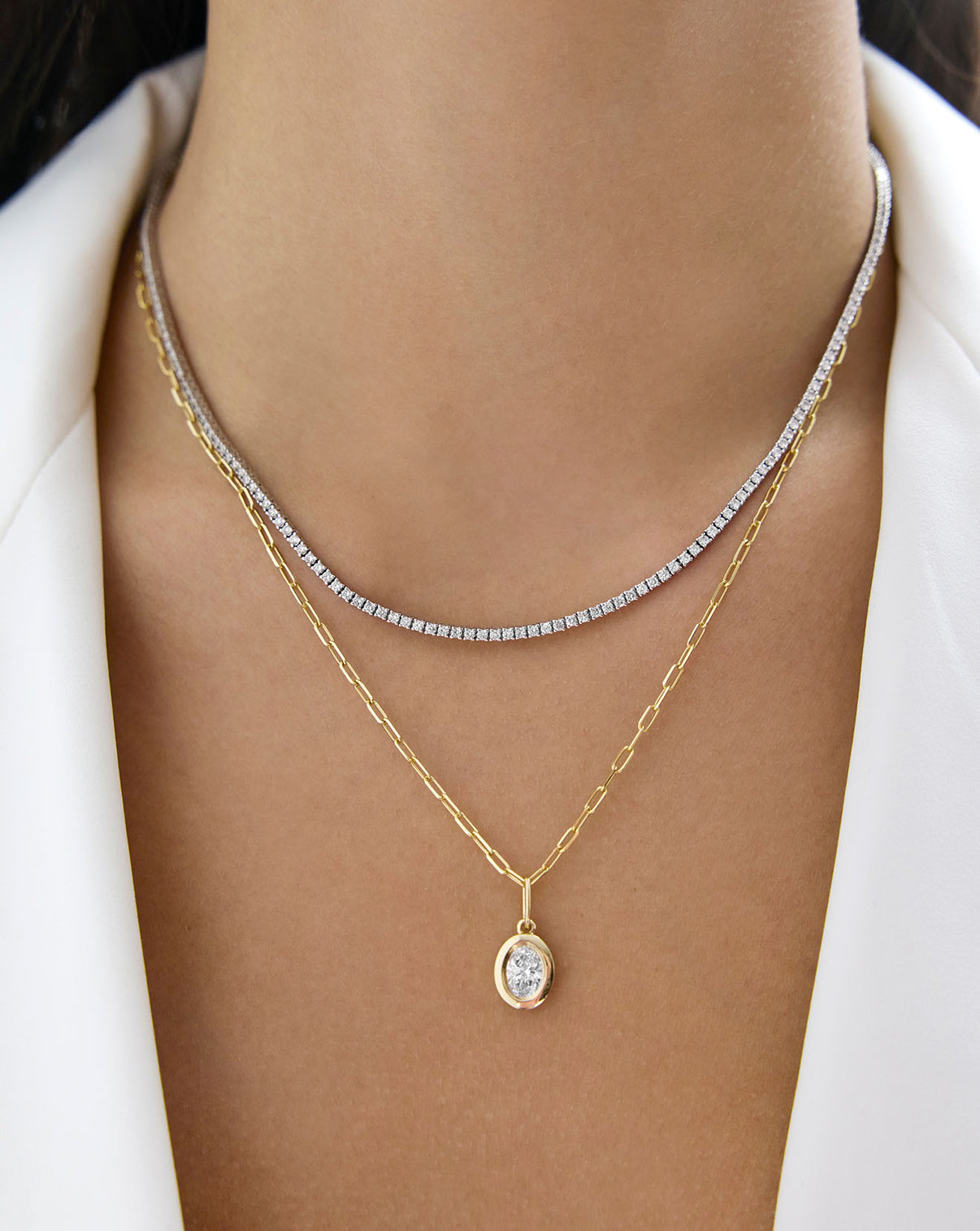 gold mini link chain necklace with a diamond pendant styled with a diamond necklace