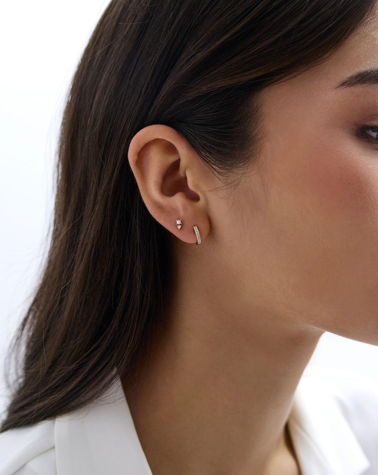Close up image of the Petite Double Row Huggies shown in ear of model styled with another diamond earring