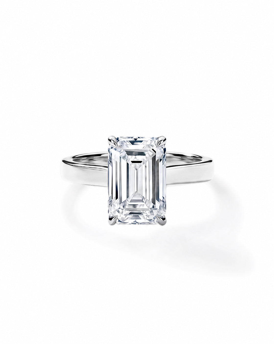 Platinum engagement ring with an emerald diamond in a four-prong setting, on a cigar-style band, shown on a white background. 44830239326296