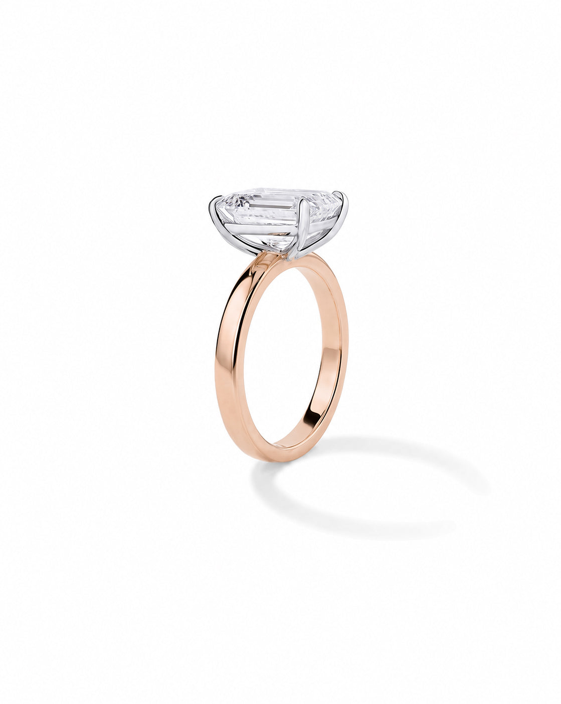 14k Rose gold engagement ring with an emerald diamond in a four-prong setting, on a cigar-style band, shown on a white background. 44830238638168