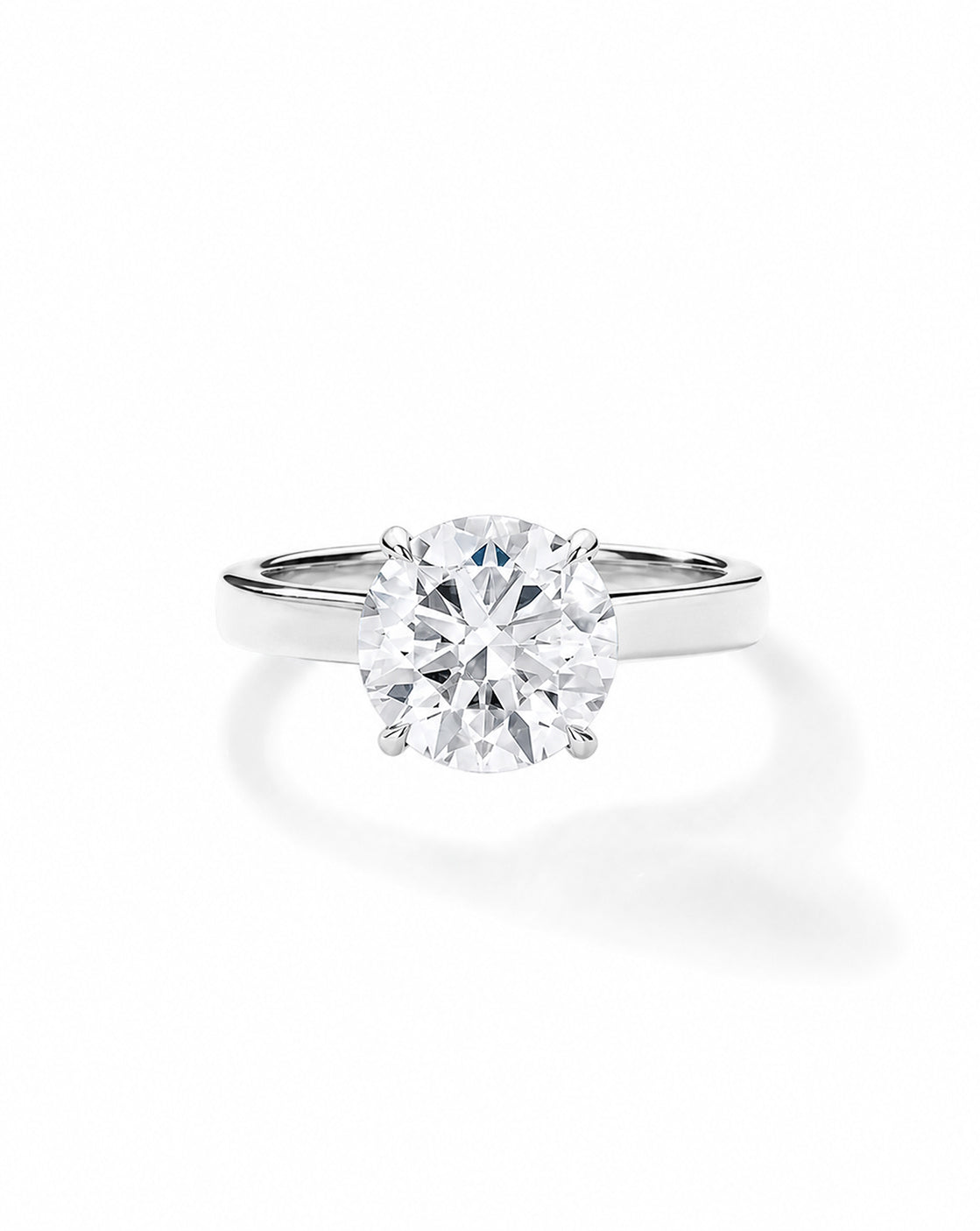 Platinum engagement ring with a round diamond in a white gold four-prong setting, on a cigar-style band, shown on a white background. 44830239129688 