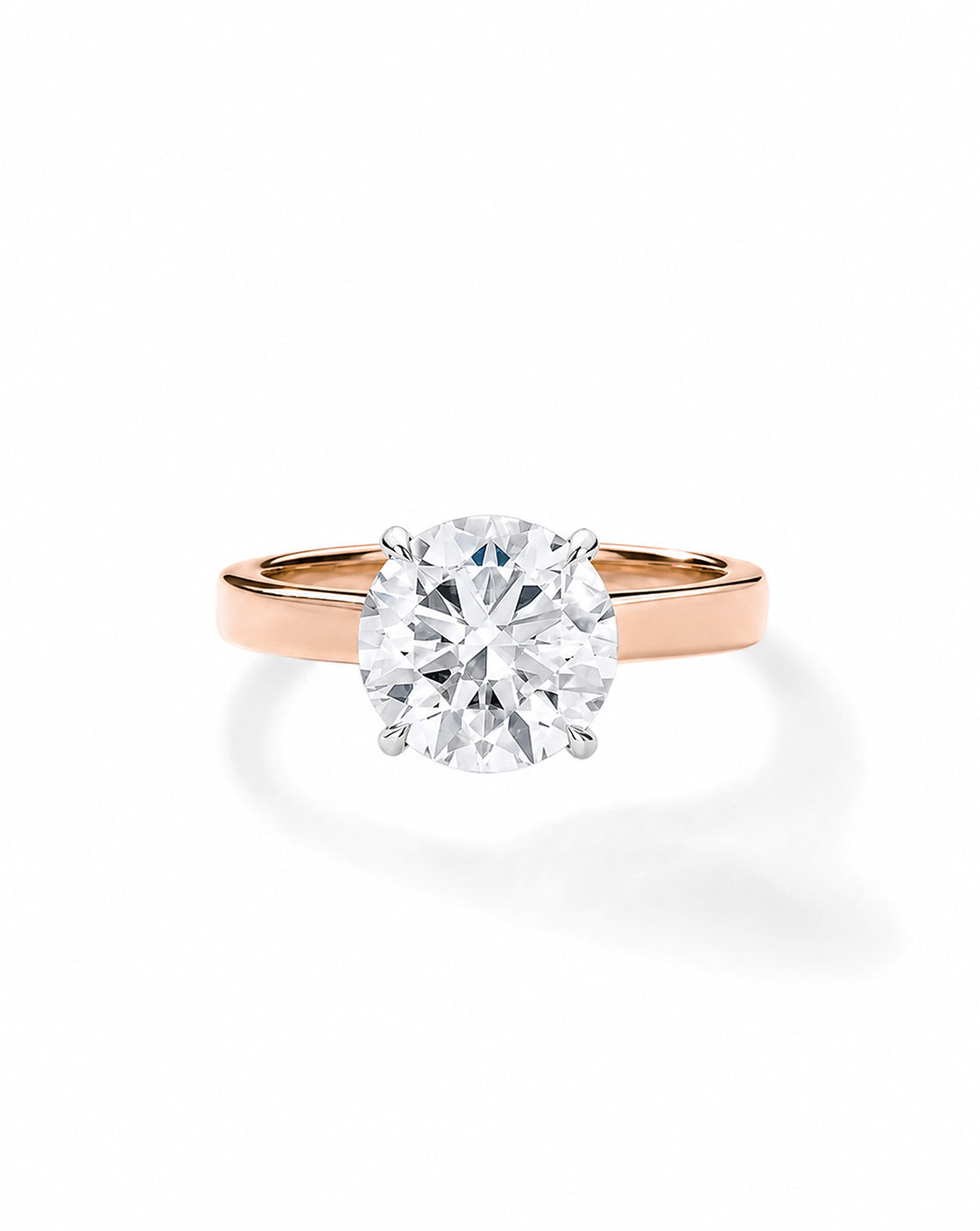 Rose gold engagement ring with a round diamond in a platinum four-prong setting, on a cigar-style band, shown on a white background. 44830238900312  