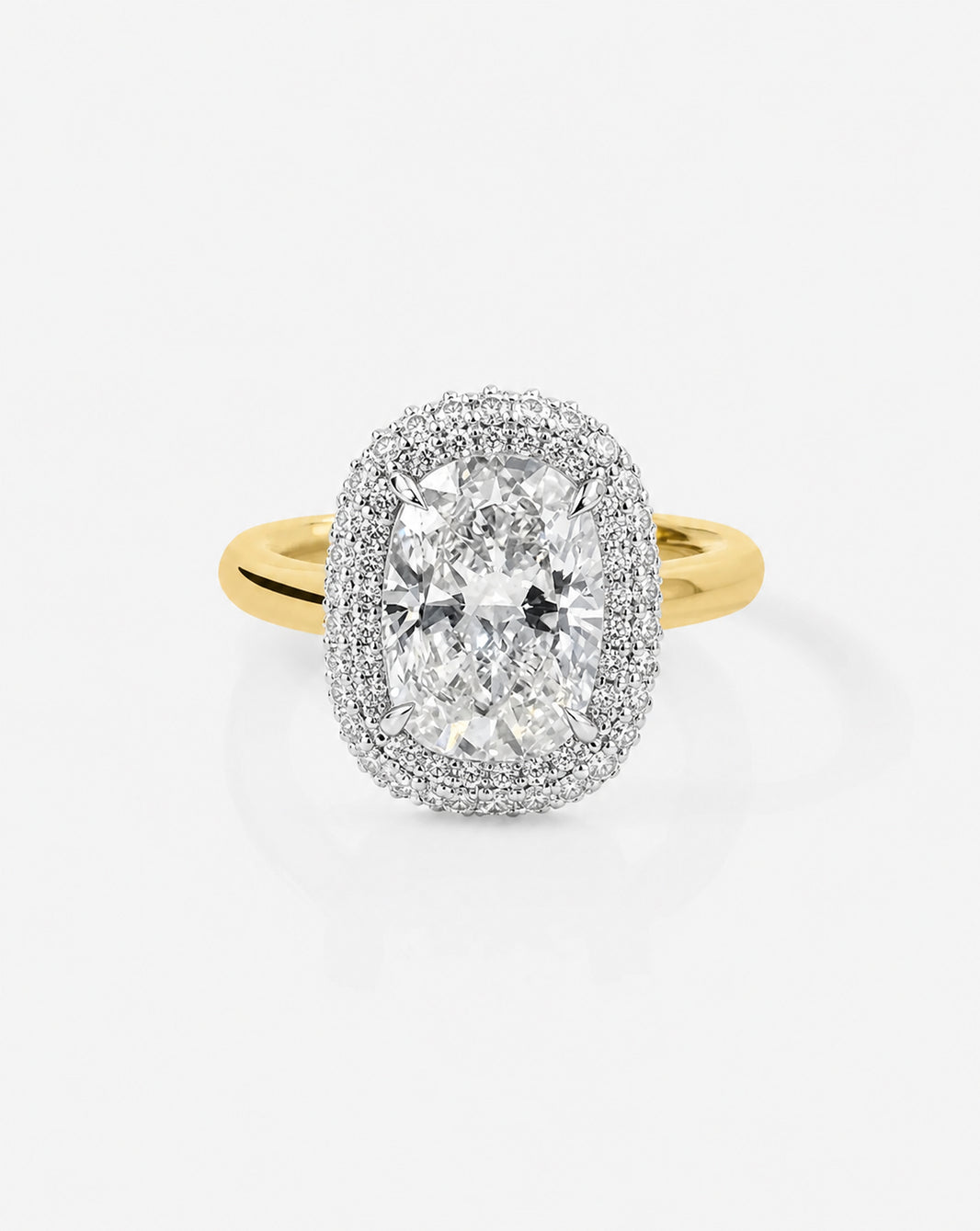 A yellow gold halo ring featuring a cushion-cut diamond center stone surrounded by a double halo of small pavé-set diamonds, shown on a light gray background.