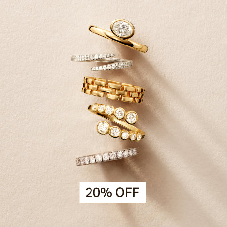 different diamond and gold rings against a travertine background