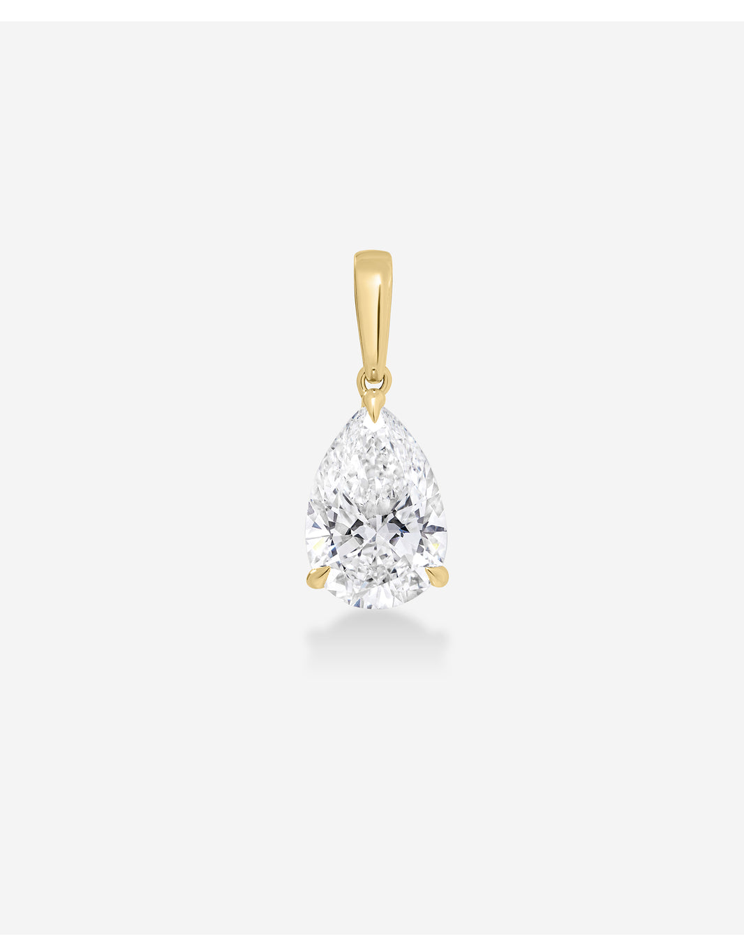 A pear-cut diamond pendant in a yellow gold setting, suspended against a clean, light gray background.
