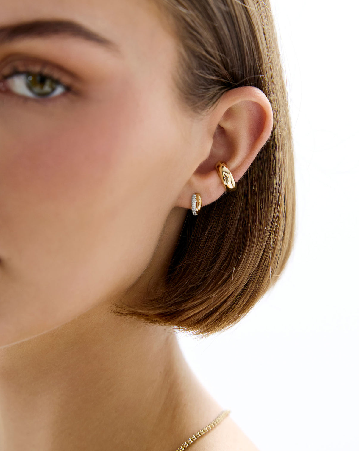 Model wearing the 14k solid gold Double Row Huggies paired with other earring styles GLOBAL