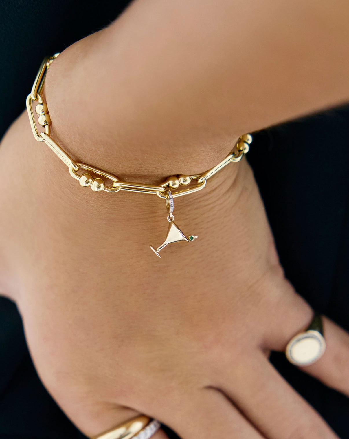 Close up of dirty martini charm being worn with bracelet on model's wrist
